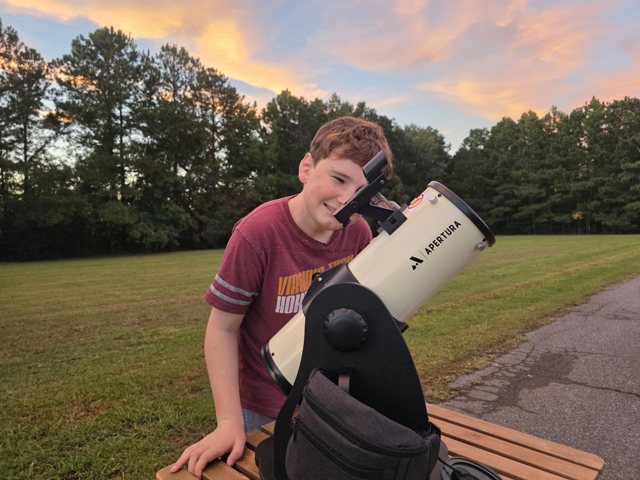 A young observer with the Apertura Library Telescope at sunset